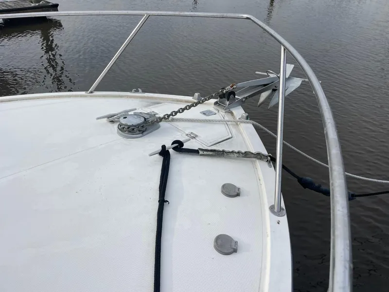 Slide: The Image of Bow of 2003 Carolina Classic 28 boat with anchor and railing, docked on calm water. - 32