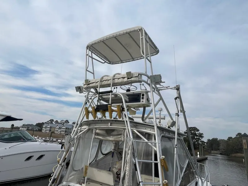 Slide: The Image of 2003 Carolina Classic 28 boat with tower, docked near waterfront homes. - 33