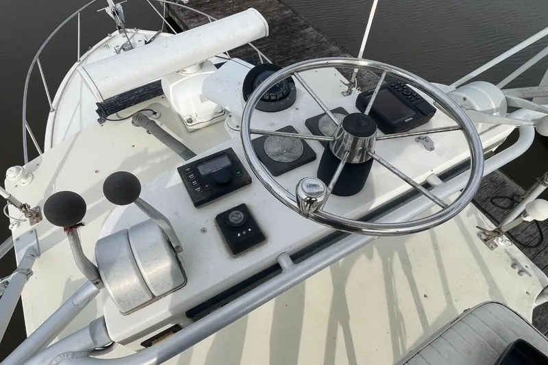Slide: The Image of 2003 Carolina Classic 28 boat helm with steering wheel and control panel. - 35