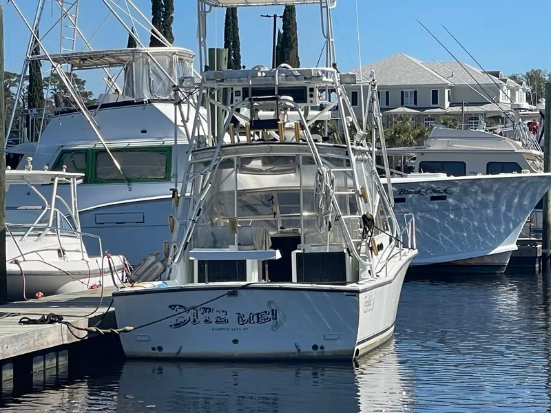 Slide: The Image of 2003 Carolina Classic 28 boat docked in a marina, surrounded by other vessels. - 36