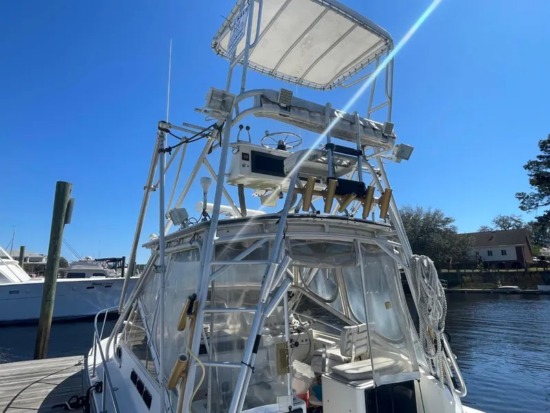 Slide: The Image of 2003 Carolina Classic 28 boat with tower docked at marina under clear blue sky. - 39