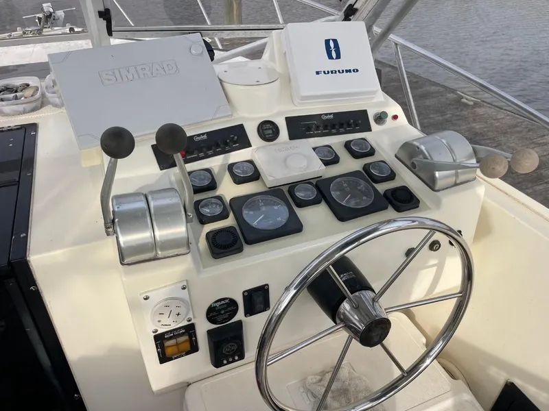 Slide: The Image of Control panel of a 2003 Carolina Classic 28 boat with steering wheel and navigation instruments. - 4