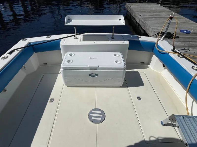Slide: The Image of 2003 Carolina Classic 28 boat deck with cooler and seating, docked by the water. - 42