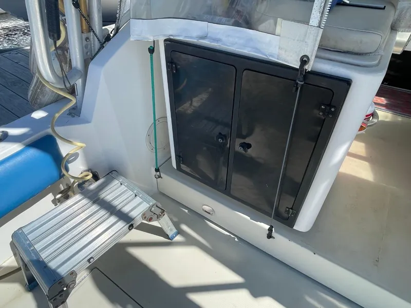 Slide: The Image of 2003 Carolina Classic 28 boat interior with storage compartment and foldable step ladder. - 43