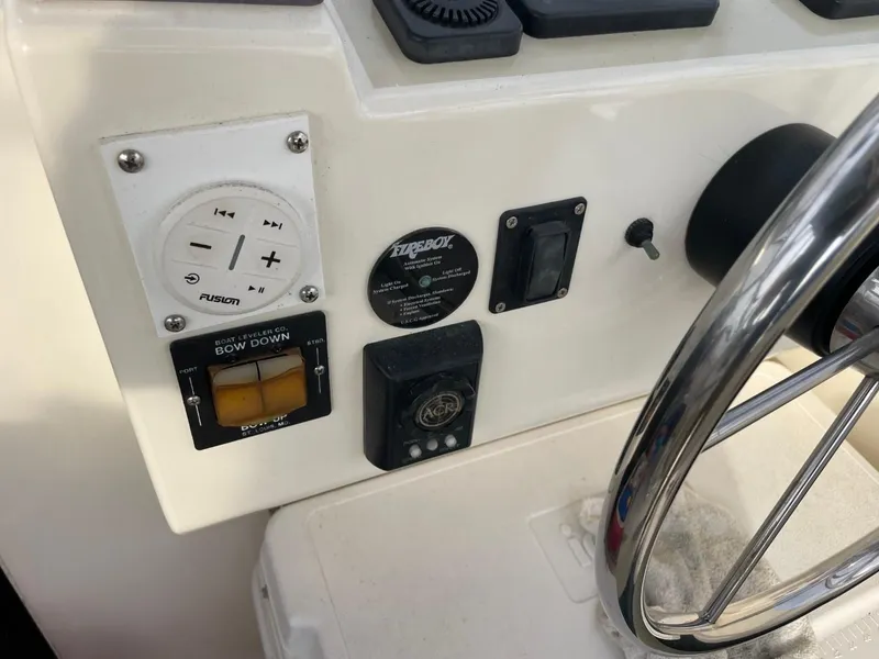 Slide: The Image of Control panel of a 2003 Carolina Classic 28 boat with steering wheel and electronic controls. - 5