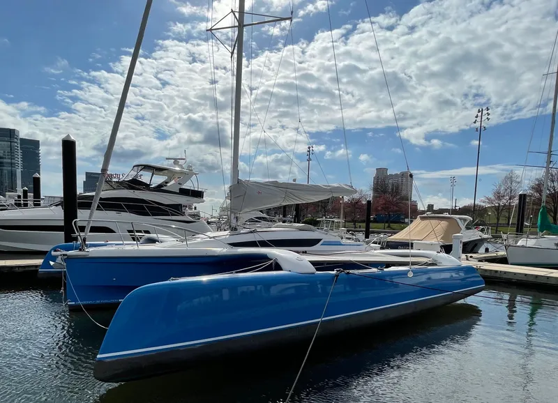 The Image of 2021 Dragonfly 32 Evolution trimaran docked at marina under partly cloudy sky. - 0