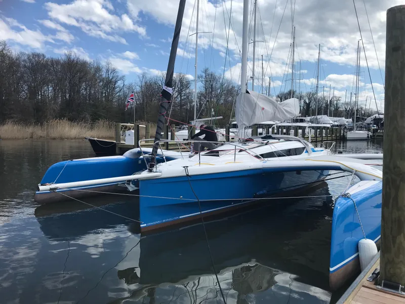 Slide: The Image of 2021 Dragonfly 32 Evolution trimaran docked in a marina under a partly cloudy sky. - 3