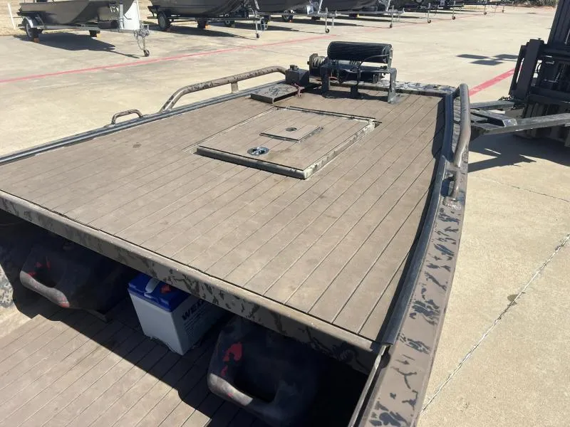 Slide: The Image of 2019 Pro-Line BTX 1848 boat deck with storage hatch and winch, parked on concrete. - 9