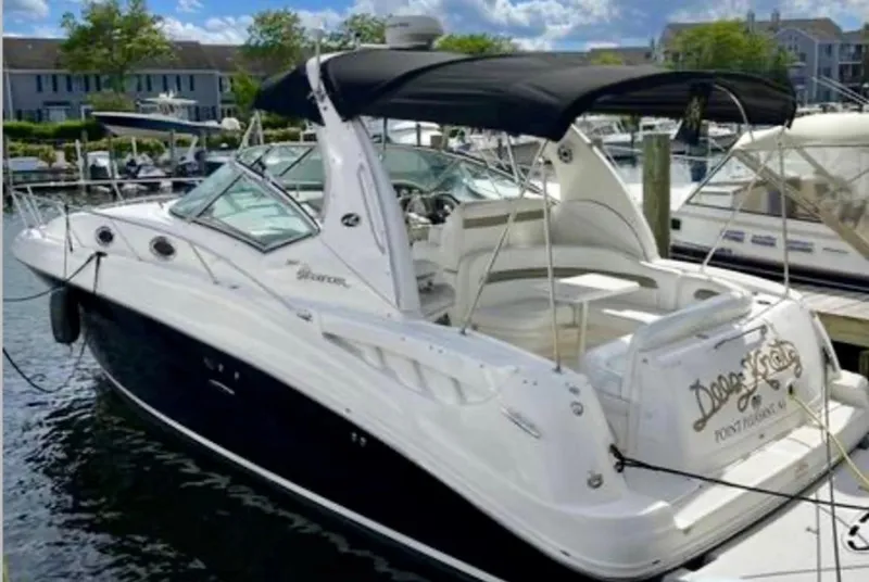 The Image of 2006 Sea Ray 320 Sundancer boat docked at marina with black canopy. - 1
