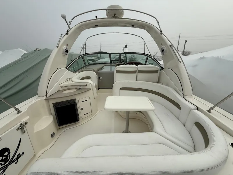 Slide: The Image of 2006 Sea Ray 320 Sundancer boat interior with white seating and table. - 12
