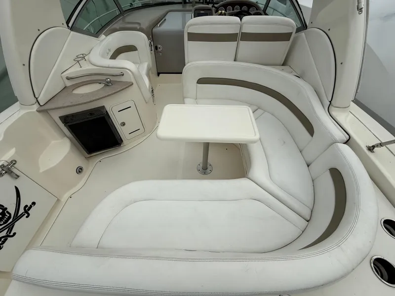 Slide: The Image of 2006 Sea Ray 320 Sundancer interior with white seating and compact table. - 13