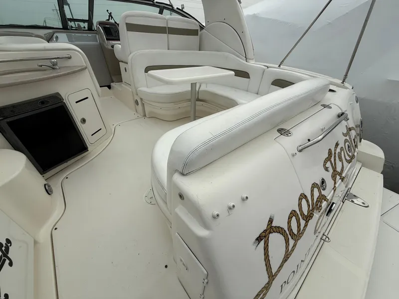 Slide: The Image of 2006 Sea Ray 320 Sundancer boat interior with white seating and table. - 15