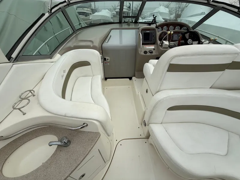 Slide: The Image of 2006 Sea Ray 320 Sundancer boat interior with white seating and helm controls. - 17