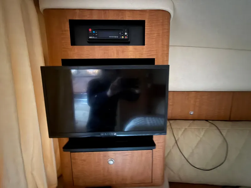 Slide: The Image of Interior of 2006 Sea Ray 320 Sundancer with mounted TV and entertainment system. - 18