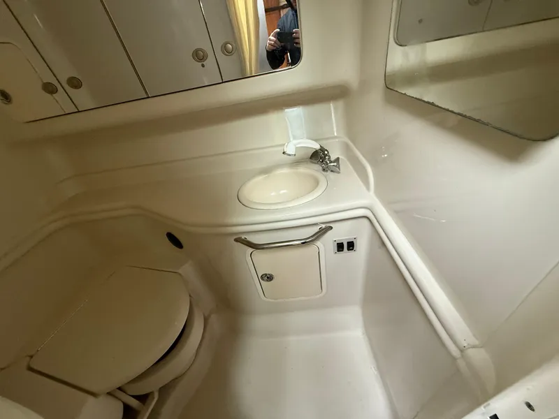 Slide: The Image of 2006 Sea Ray 320 Sundancer bathroom with sink, toilet, and storage cabinets. - 23