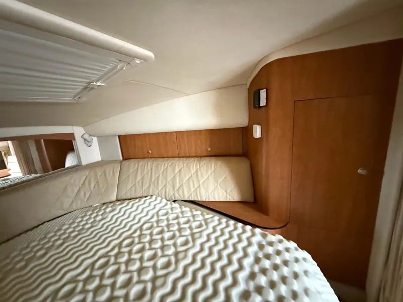 Slide: The Image of Interior cabin of 2006 Sea Ray 320 Sundancer with quilted bedding and wood paneling. - 28