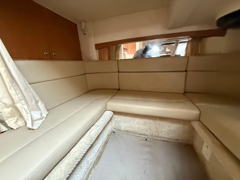 Slide: The Image of 2006 Sea Ray 320 Sundancer interior with beige seating and wooden cabinets. - 29