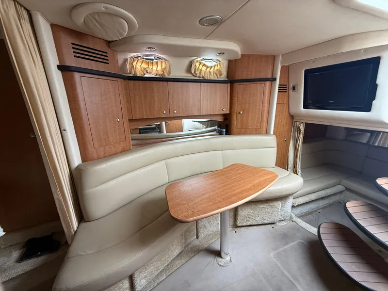 Slide: The Image of Interior of 2006 Sea Ray 320 Sundancer with beige seating and wooden cabinetry. - 31