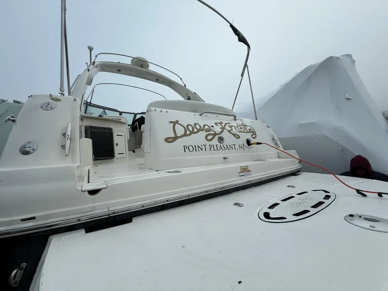 Slide: The Image of 2006 Sea Ray 320 Sundancer boat docked, featuring a white exterior and visible deck details. - 34