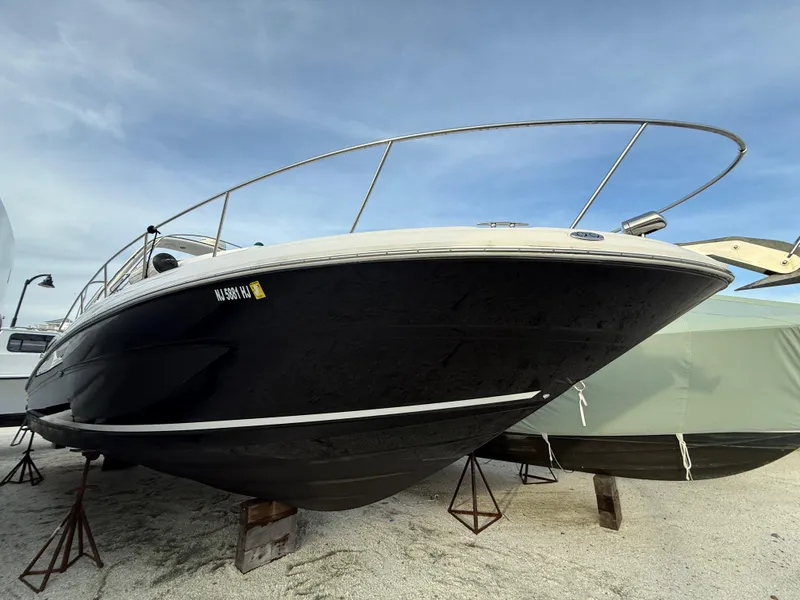 Slide: The Image of 2006 Sea Ray 320 Sundancer boat on stands, black hull, outdoor storage. - 35