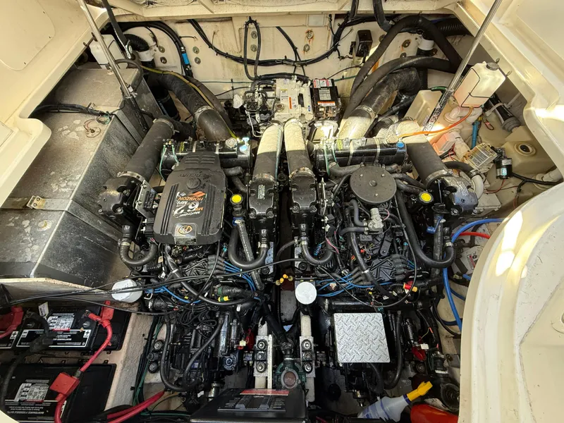 Slide: The Image of Engine compartment of a 2006 Sea Ray 320 Sundancer boat, showcasing dual engines and wiring. - 36