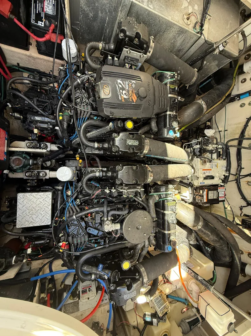 Slide: The Image of Engine compartment of a 2006 Sea Ray 320 Sundancer boat, showcasing complex machinery and wiring. - 48