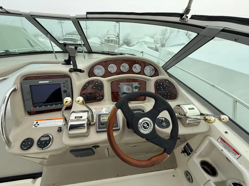 Slide: The Image of Helm of 2006 Sea Ray 320 Sundancer with gauges, steering wheel, and navigation equipment. - 5
