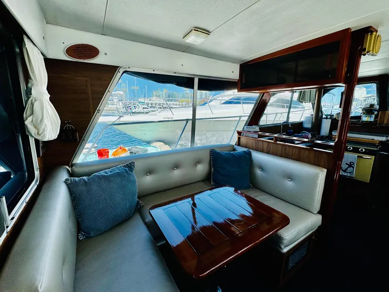 Slide: The Image of 1978 Tollycraft 30 Sedan interior with modern Cummins 6bt diesel motors, featuring cozy seating and table. - 15