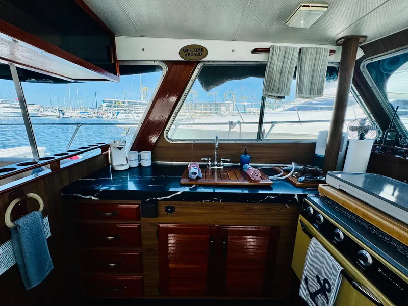 Slide: The Image of 1978 Tollycraft 30 Sedan kitchen with modern Cummins 6bt diesel motors, docked at marina. - 18