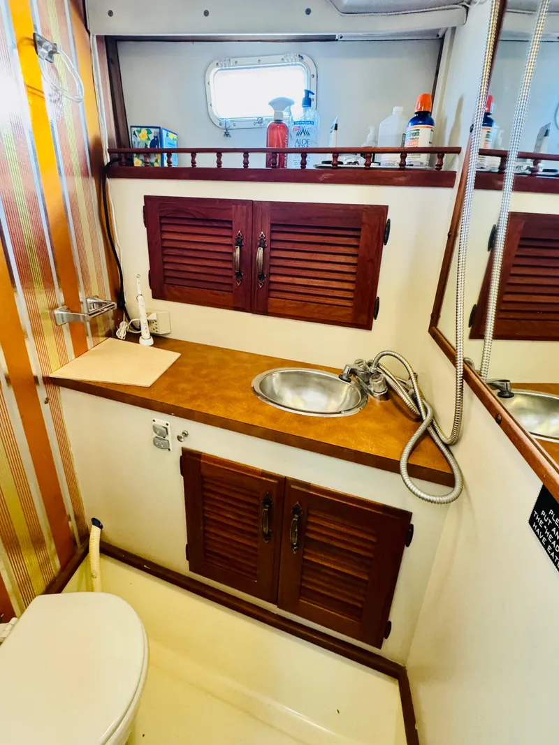 Slide: The Image of 1978 Tollycraft 30 Sedan bathroom with wooden cabinets and stainless steel sink. - 22