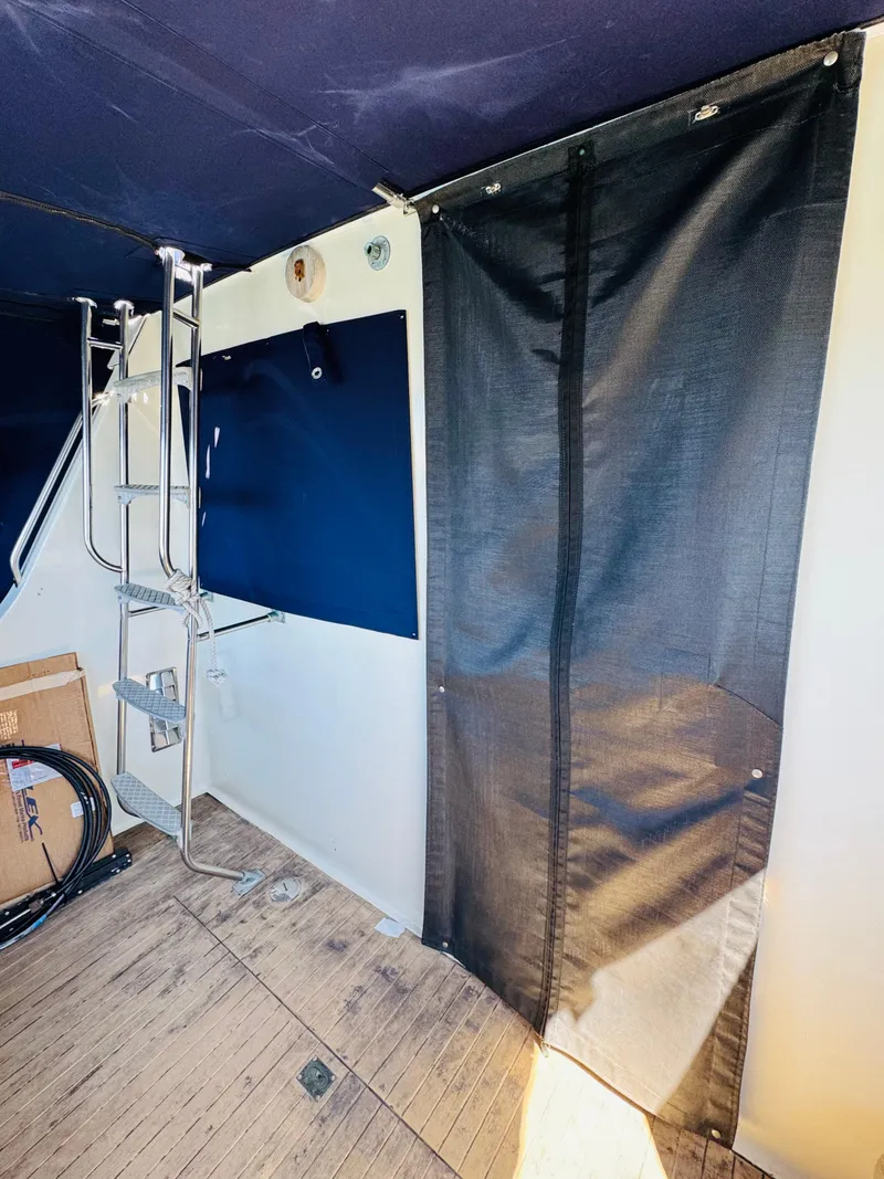 Slide: The Image of 1978 Tollycraft 30 Sedan interior with ladder, mesh curtain, and wooden flooring. - 23