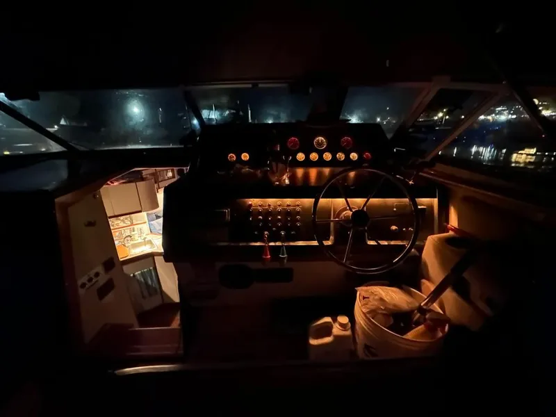 Slide: The Image of 1989 Regal Commodore 360 boat interior at night, featuring illuminated dashboard and steering wheel. - 13