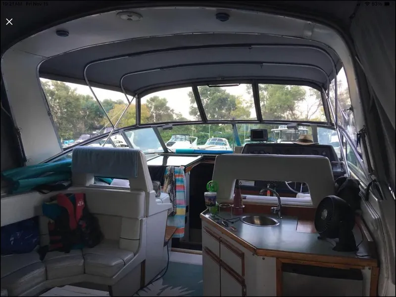 Slide: The Image of Interior of 1989 Regal Commodore 360 boat with seating, kitchenette, and helm. - 16