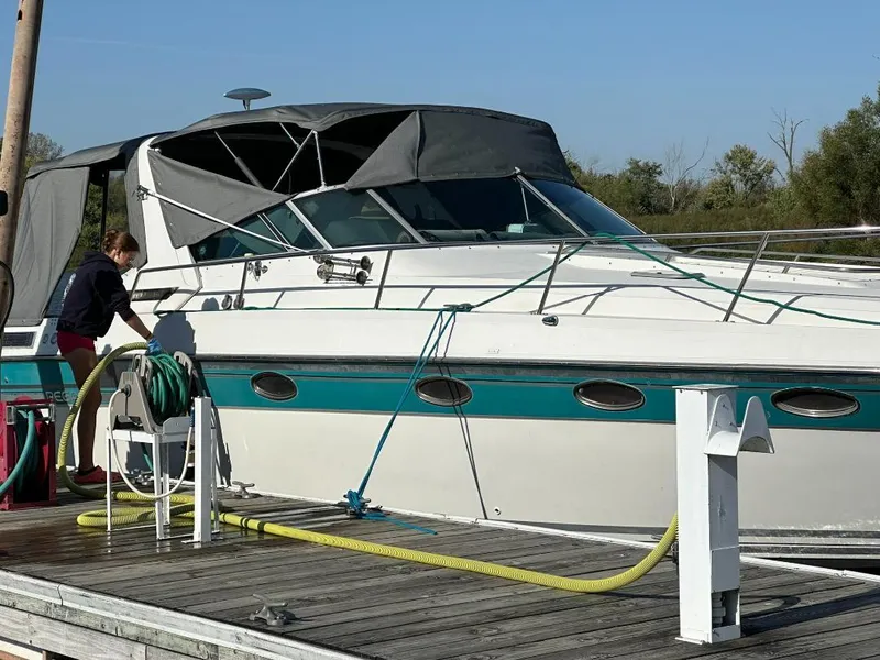 Slide: The Image of 1989 Regal Commodore 360 boat docked, with person handling equipment on a sunny day. - 3