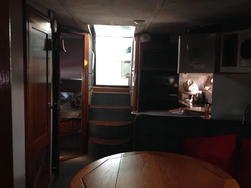 Slide: The Image of Interior of 1989 Regal Commodore 360 yacht, featuring wooden table, kitchenette, and stairs to deck. - 5