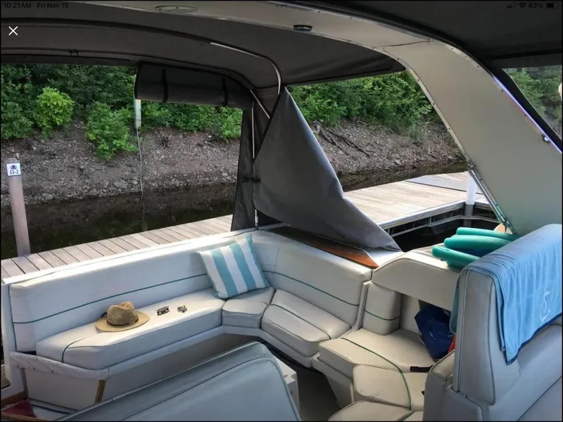 Slide: The Image of 1989 Regal Commodore 360 boat interior with seating, docked by lush greenery. - 6