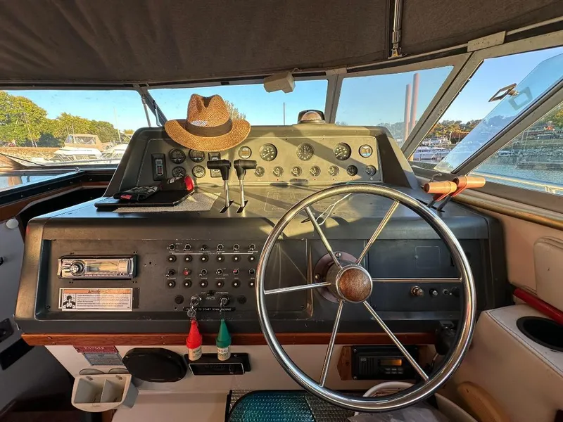 Slide: The Image of 1989 Regal Commodore 360 boat helm with steering wheel, control panel, and hat. - 9