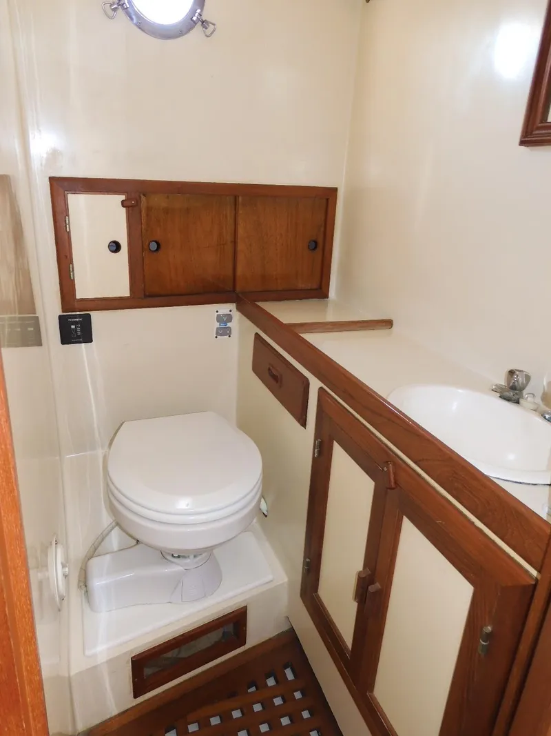 Slide: The Image of 1985 Sundowner Tug 30 bathroom with wooden cabinets and compact toilet. - 10