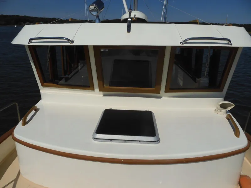 Slide: The Image of 1985 Sundowner Tug 30 boat deck with windows and hatch, docked on a sunny day. - 12