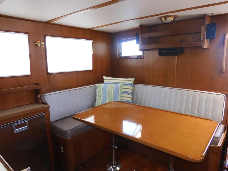 Slide: The Image of Interior of 1985 Sundowner Tug 30 with wooden table and cushioned seating. - 3