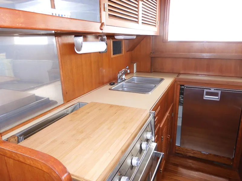 Slide: The Image of 1985 Sundowner Tug 30 galley with wooden cabinetry, stainless steel sink, and compact appliances. - 4
