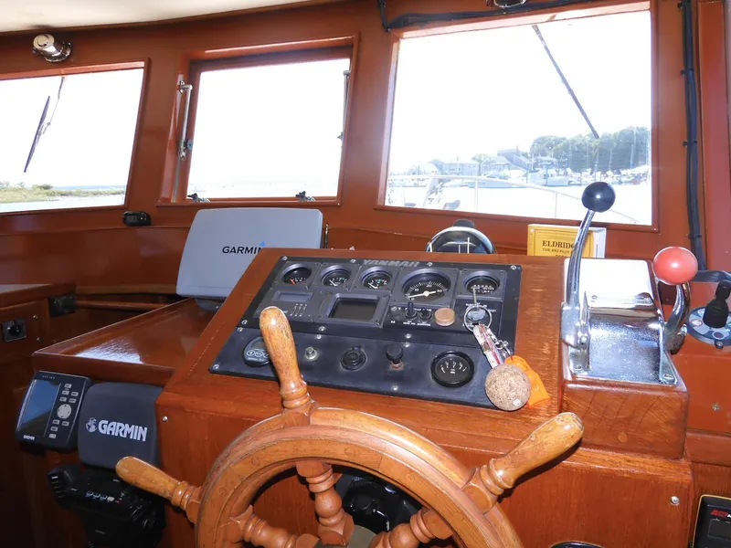 Slide: The Image of 1985 Sundowner Tug 30 helm with wooden wheel, Garmin navigation, and control panel. - 7