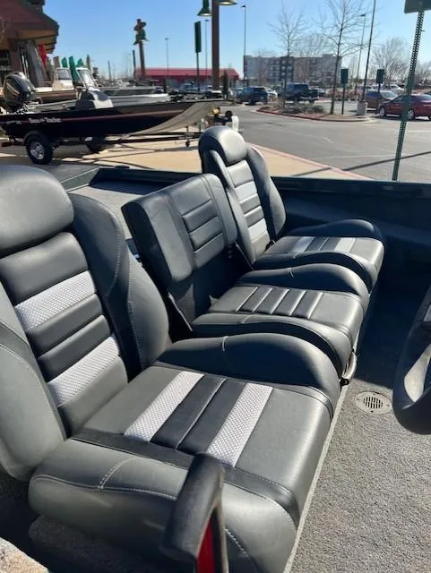 Slide: The Image of 2024 Ranger RT188 boat interior with black and gray seating in a parking lot. - 6