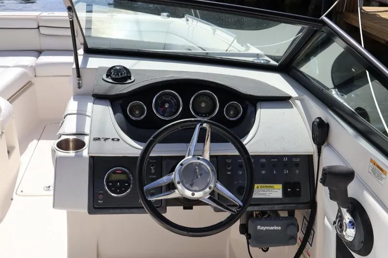 Slide: The Image of 2015 Sea Ray 270 Sundeck Outboard dashboard with steering wheel and controls. - 10