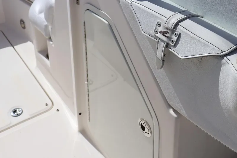 Slide: The Image of 2015 Sea Ray 270 Sundeck Outboard interior detail, featuring white seating and storage compartment. - 12