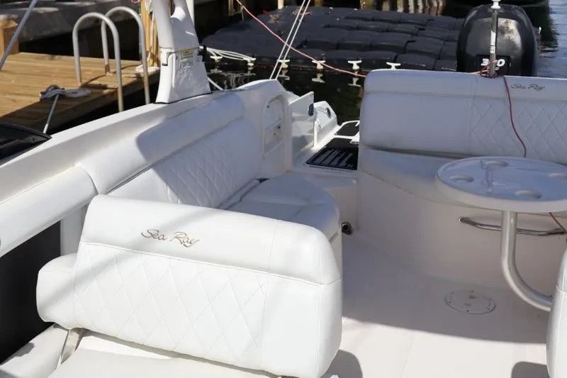 Slide: The Image of 2015 Sea Ray 270 Sundeck Outboard interior with white seating and table. - 22