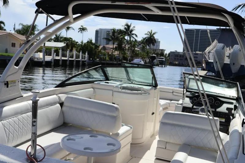 Slide: The Image of 2015 Sea Ray 270 Sundeck Outboard boat with white interior, docked near waterfront homes. - 5