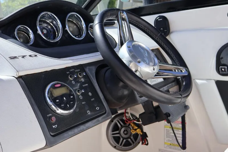 Slide: The Image of 2015 Sea Ray 270 Sundeck Outboard dashboard with steering wheel and control panel. - 8
