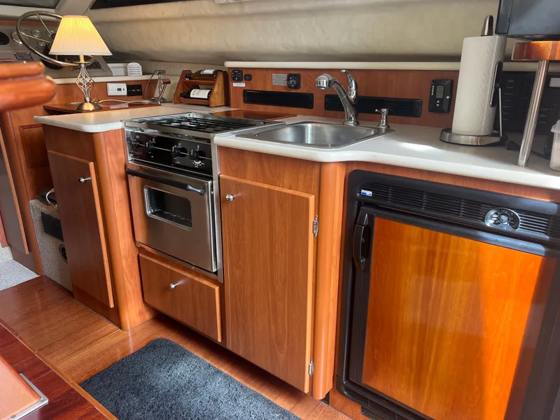 Slide: The Image of 2004 Bayliner 288 Ciara Classic Command Bridge kitchen with stove, sink, and fridge. - 11