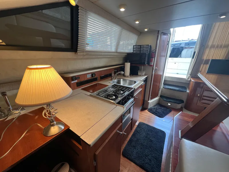 Slide: The Image of Interior of 2004 Bayliner 288 Ciara Classic Command Bridge with kitchen and cozy lighting. - 18